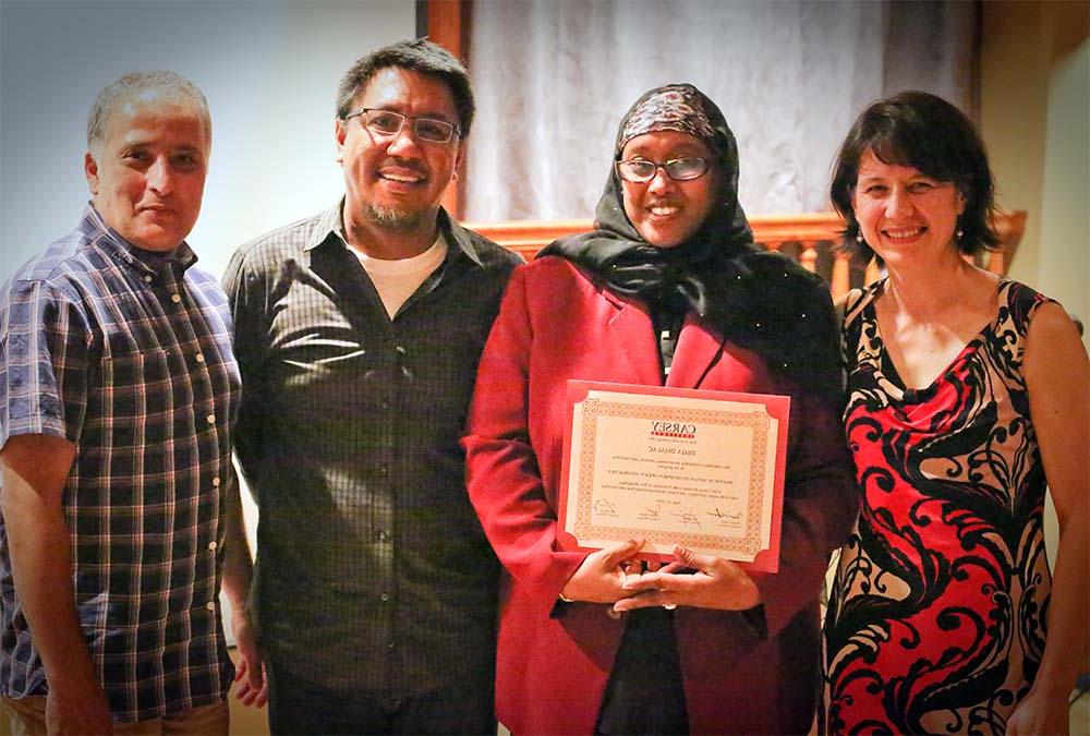 德卡·达拉克(左二)站在社区发展硕士项目导师身旁的照片