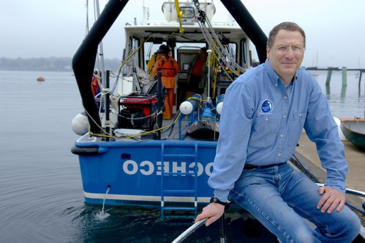 Larry Mayer sits on the stern of a UNH research vessel