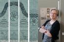 Artist Lindsay Olson next to her textile art. 