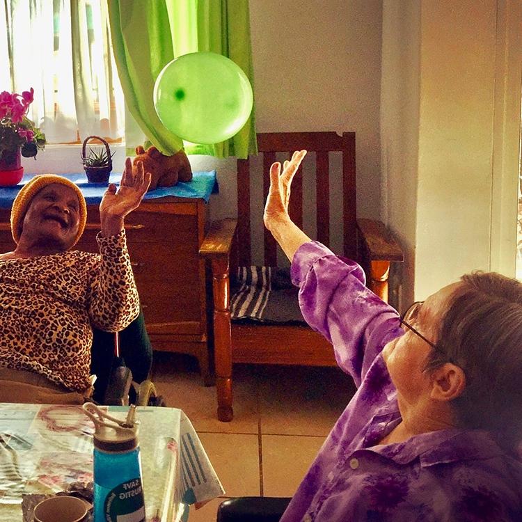 two women vollying a balloon between them
